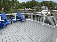 <b>A riverfont deck with Trex Select Pebble Gray Composite deck boards with white vinyl railing with black aluminum baluters</b>